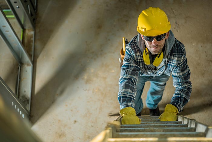 Professionnel équipé de son casque sur une échelle